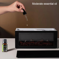 Hand dropping essential oil into a diffuser with a bottle of tea tree oil on a neutral background