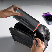 Person opening a black leather case to reveal a smartphone, with another phone visible in the background.