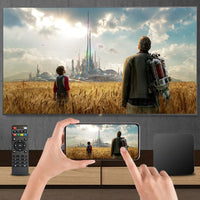 Person using a smartphone to mirror a scene from a TV screen showing two characters in a futuristic landscape.